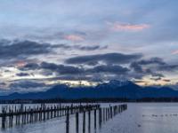 Morgenstimmung am Chiemsee mit dunklen Wolken und farbigen Wolkenfetzen